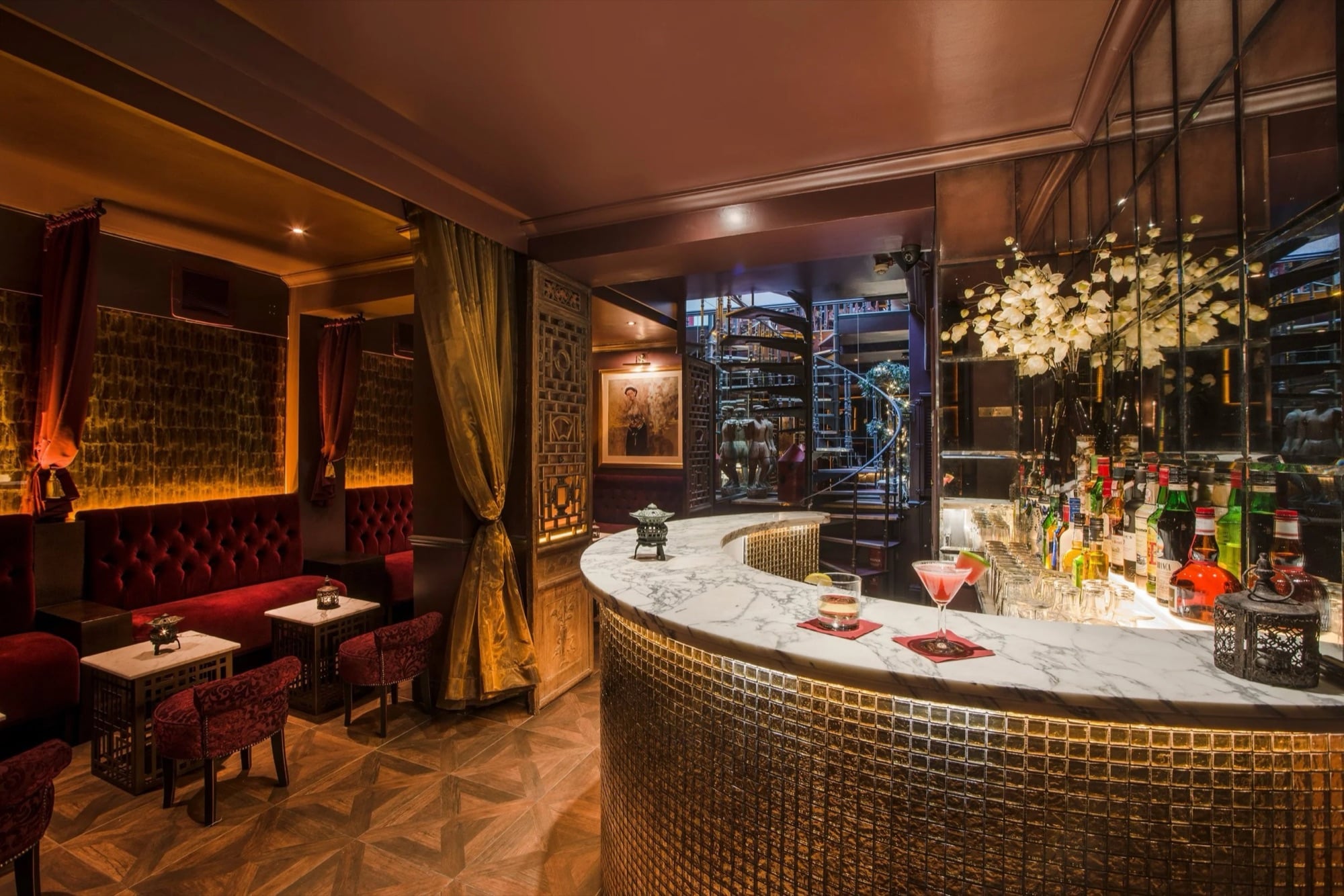 The dining room with velvet banquettes and the marble bar